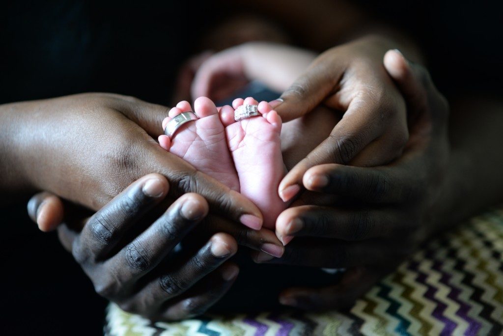 hands holding baby's feet Providence Moms Blog