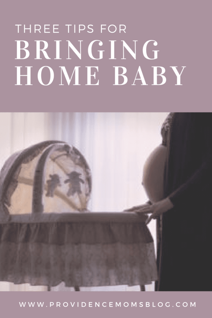 pregnant woman standing next to bassinet Providence Moms Blog