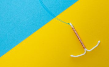 And IUD on on a blue and yellow background to illustrate IUD failure