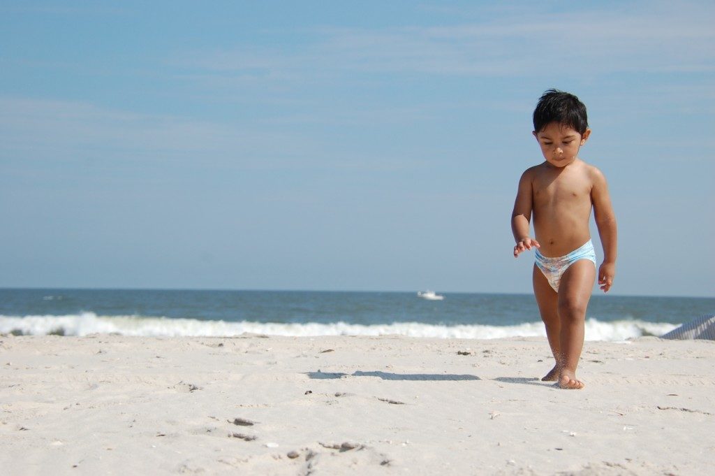 baby boy walking on beach in summer Providence Moms Blog