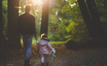 Father walking with daughter in woods Providence Moms Blog