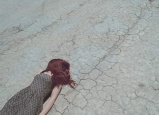 woman lying face down on cracked ground Providence moms Blog