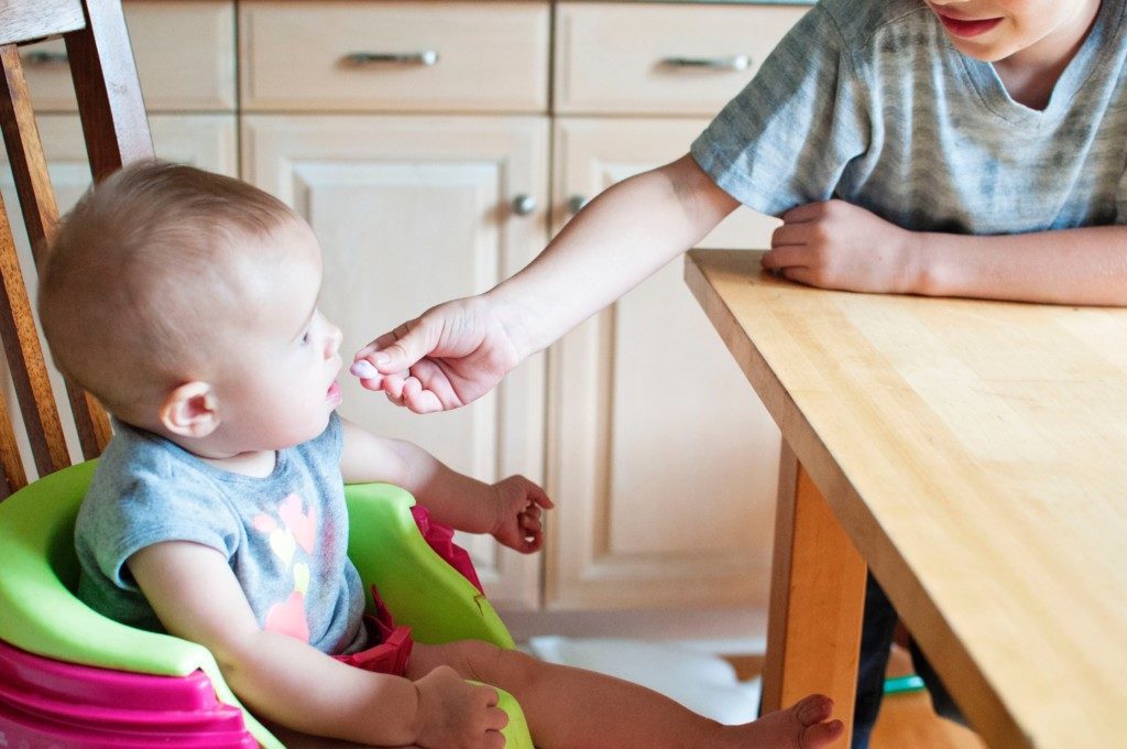child feeding baby sibling Providence Moms Blog