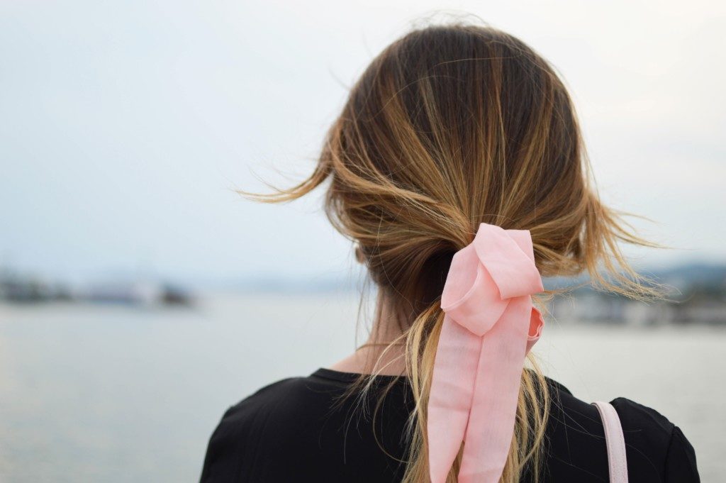 woman wearing pink ribbon in her hair