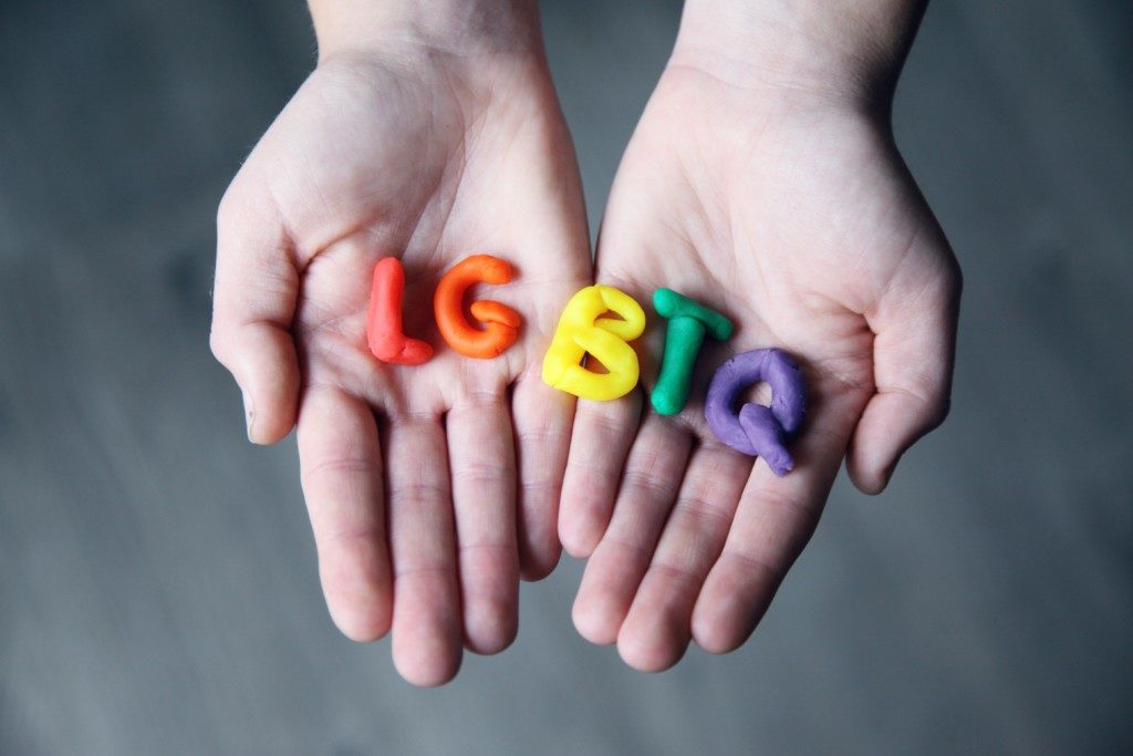 LGBTQ rainbow letters in someone's hand Providence Moms Blog