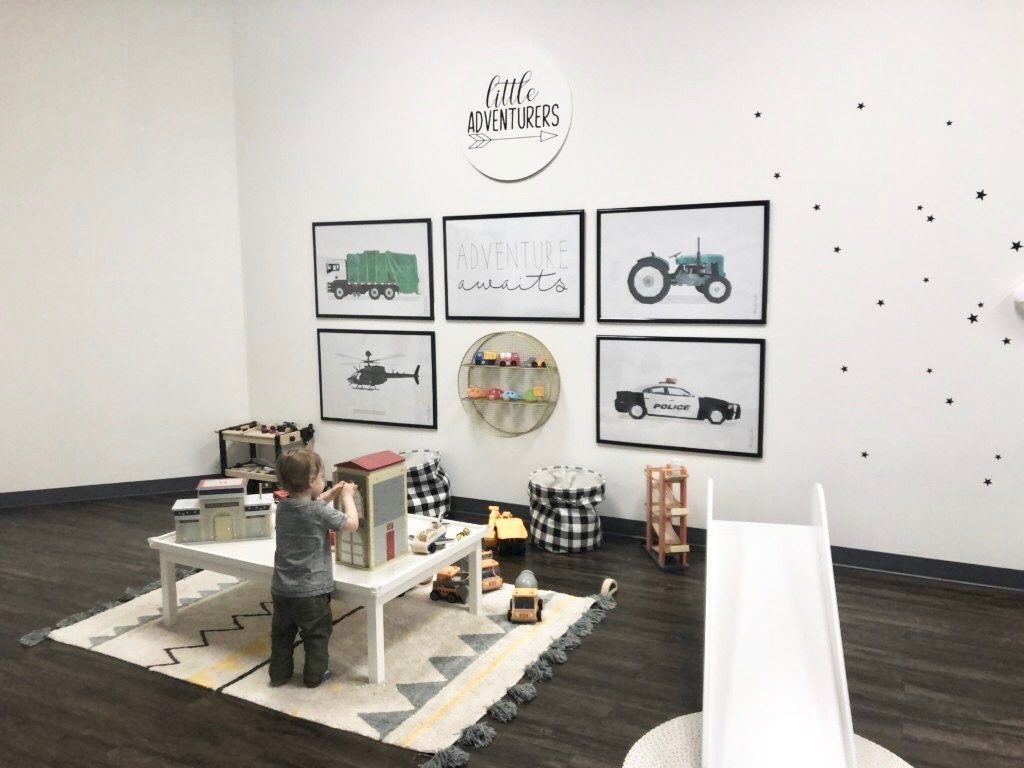 small child standing at child sized table in the indoor playspace little seeds