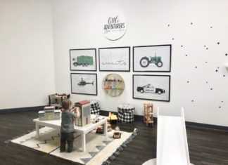 small child standing at child sized table in the indoor playspace little seeds