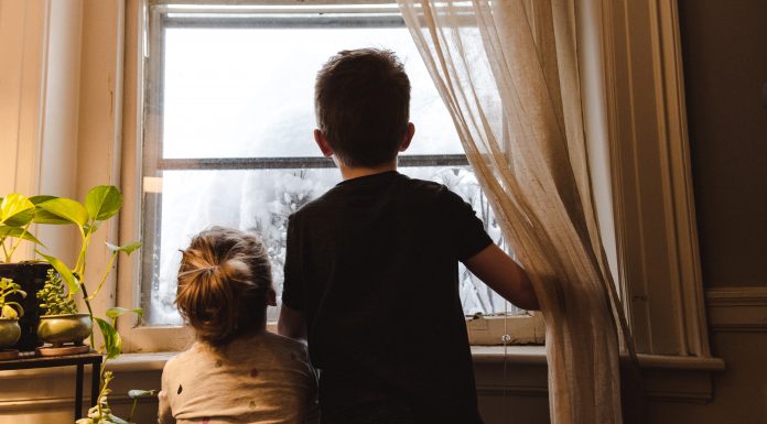 2 children looking out window