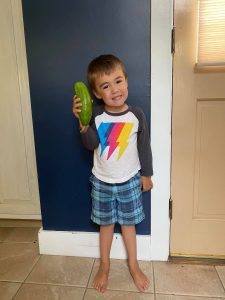 preschooler holding a cucumber