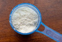 A measuring cup full of powdered baby formula