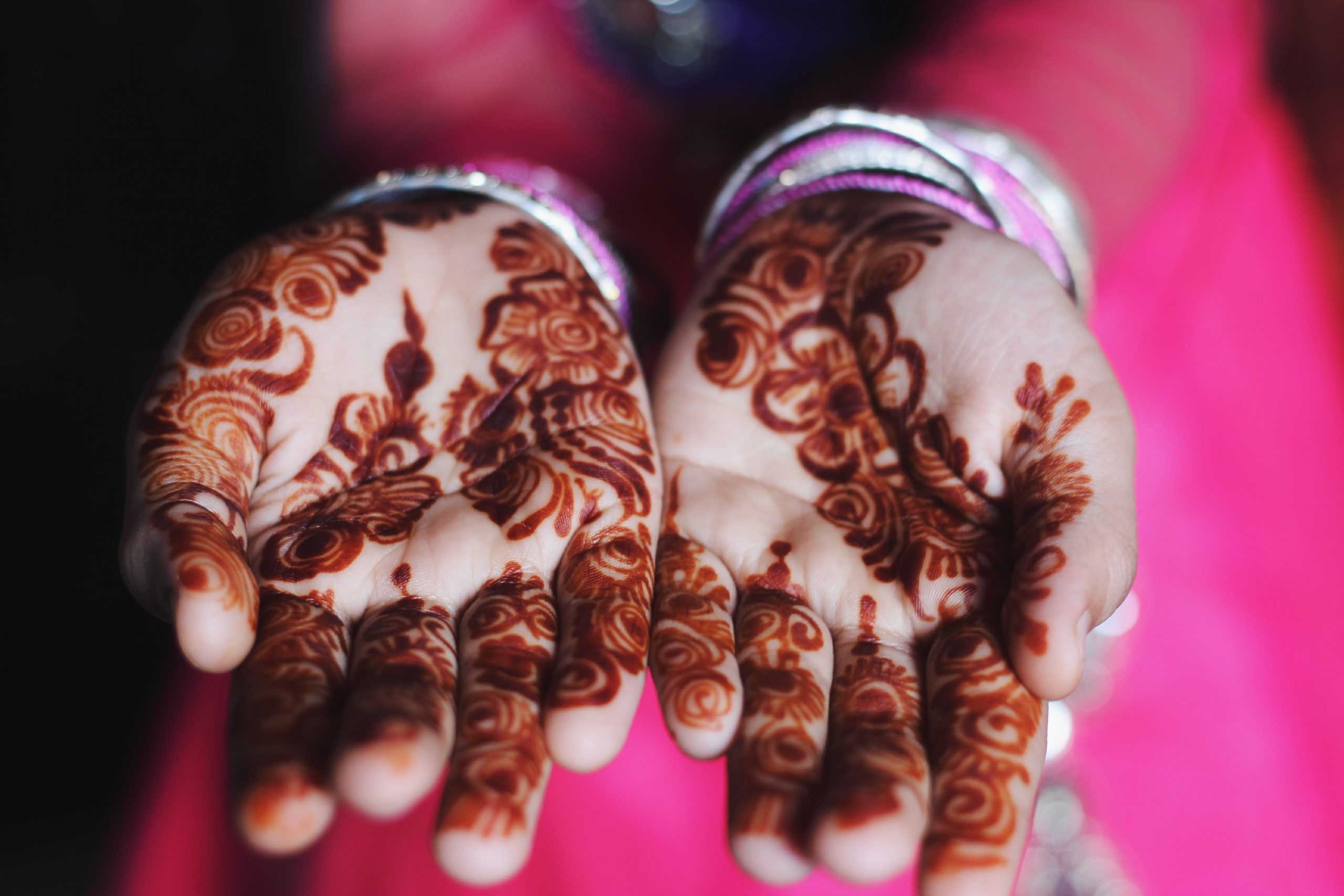Hands adorned with decorative henna tattoos