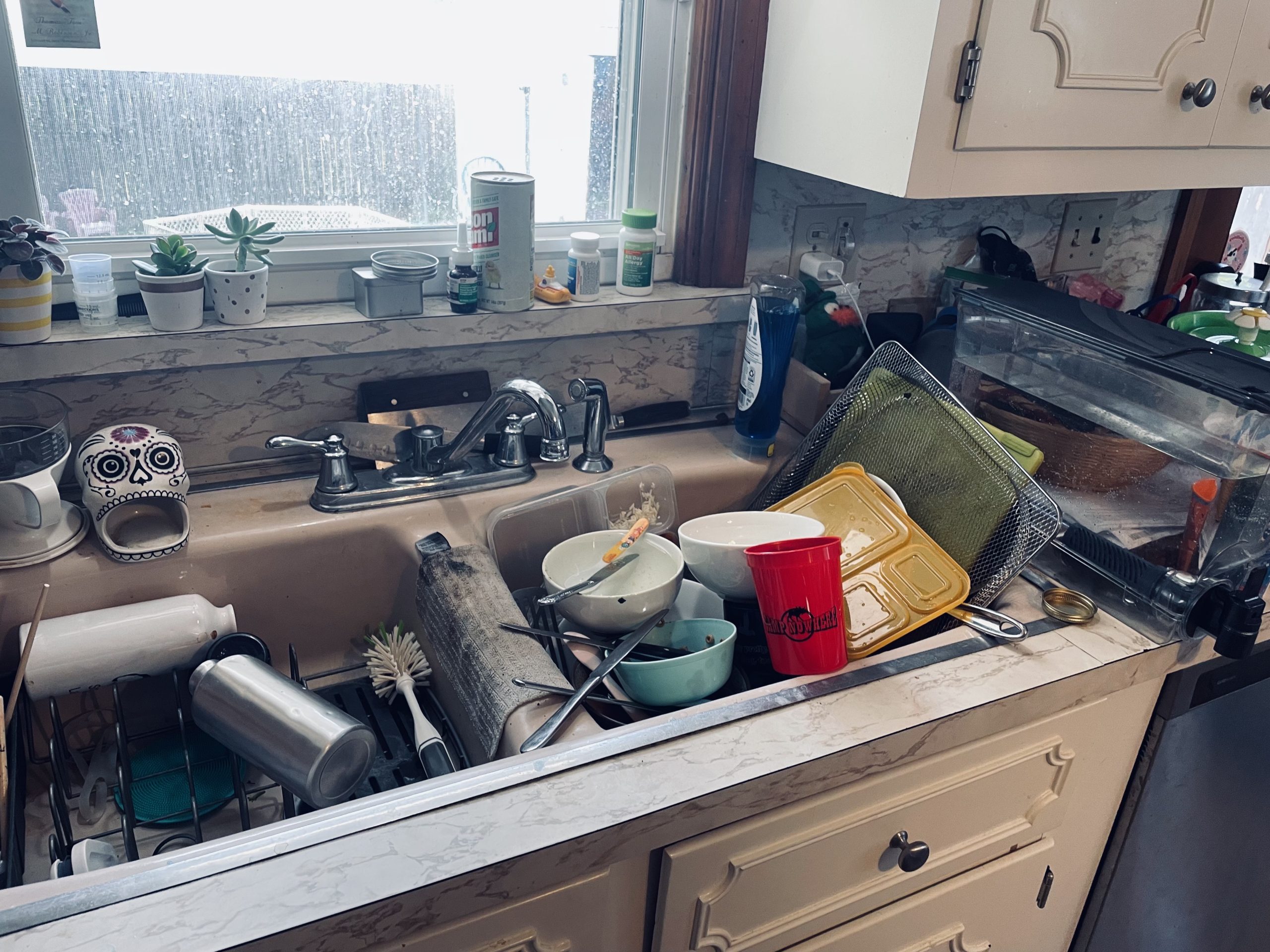 messy house with kitchen sink full of dirty dishes 